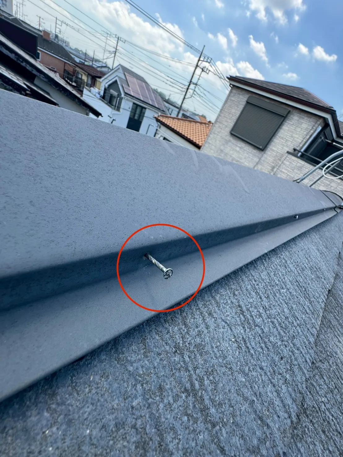 棟板金の側面から固定釘が大きく浮き出た状態